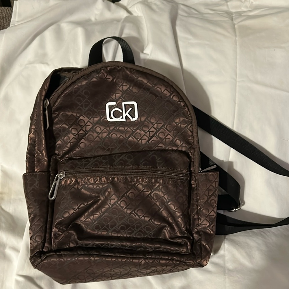 Brown all over logo Calvin Klein backpack purse.2 side,1 back,1 front pocket
